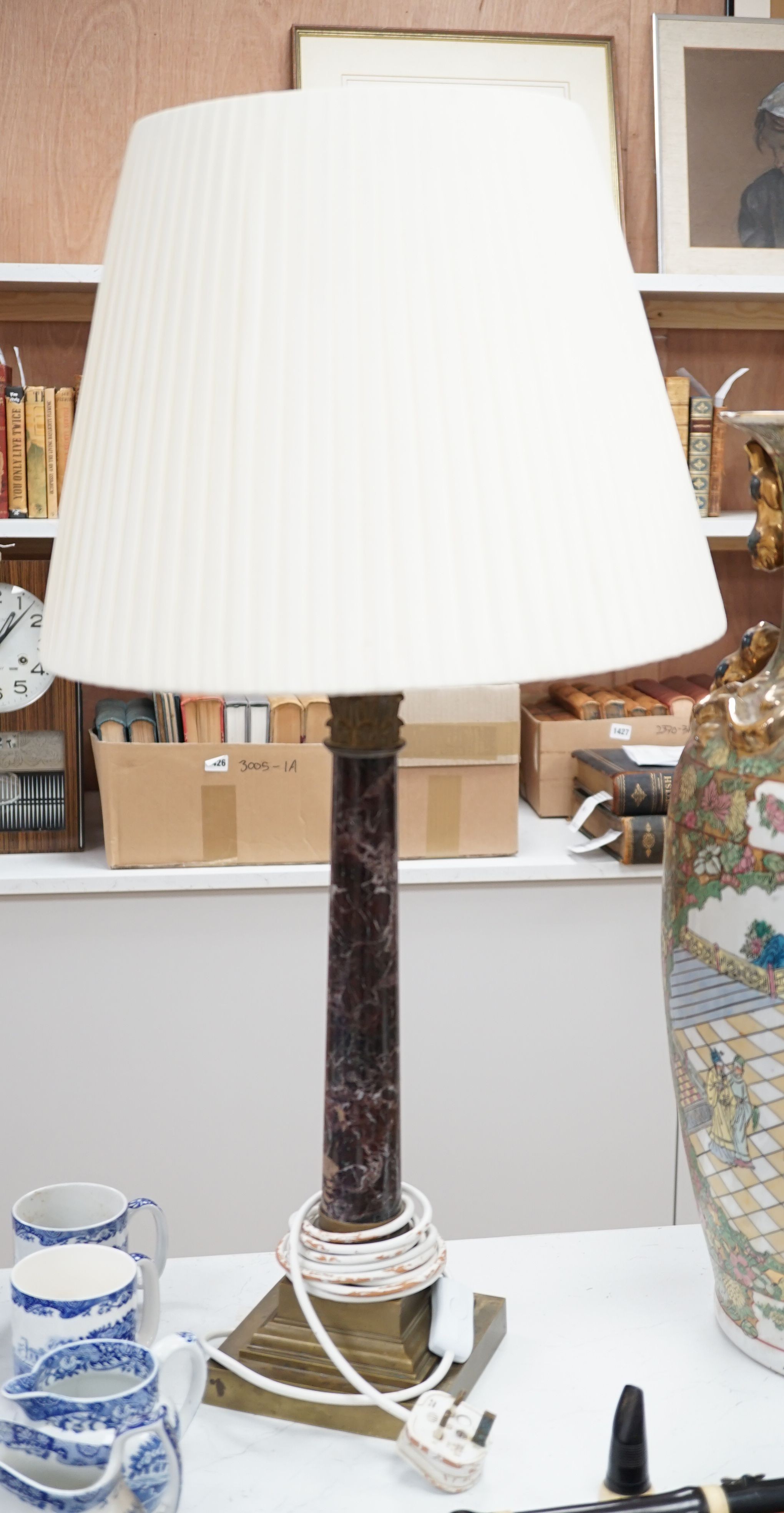 A brass and variegated marble Corinthian column lamp base, 47cms high, not including light fitting.